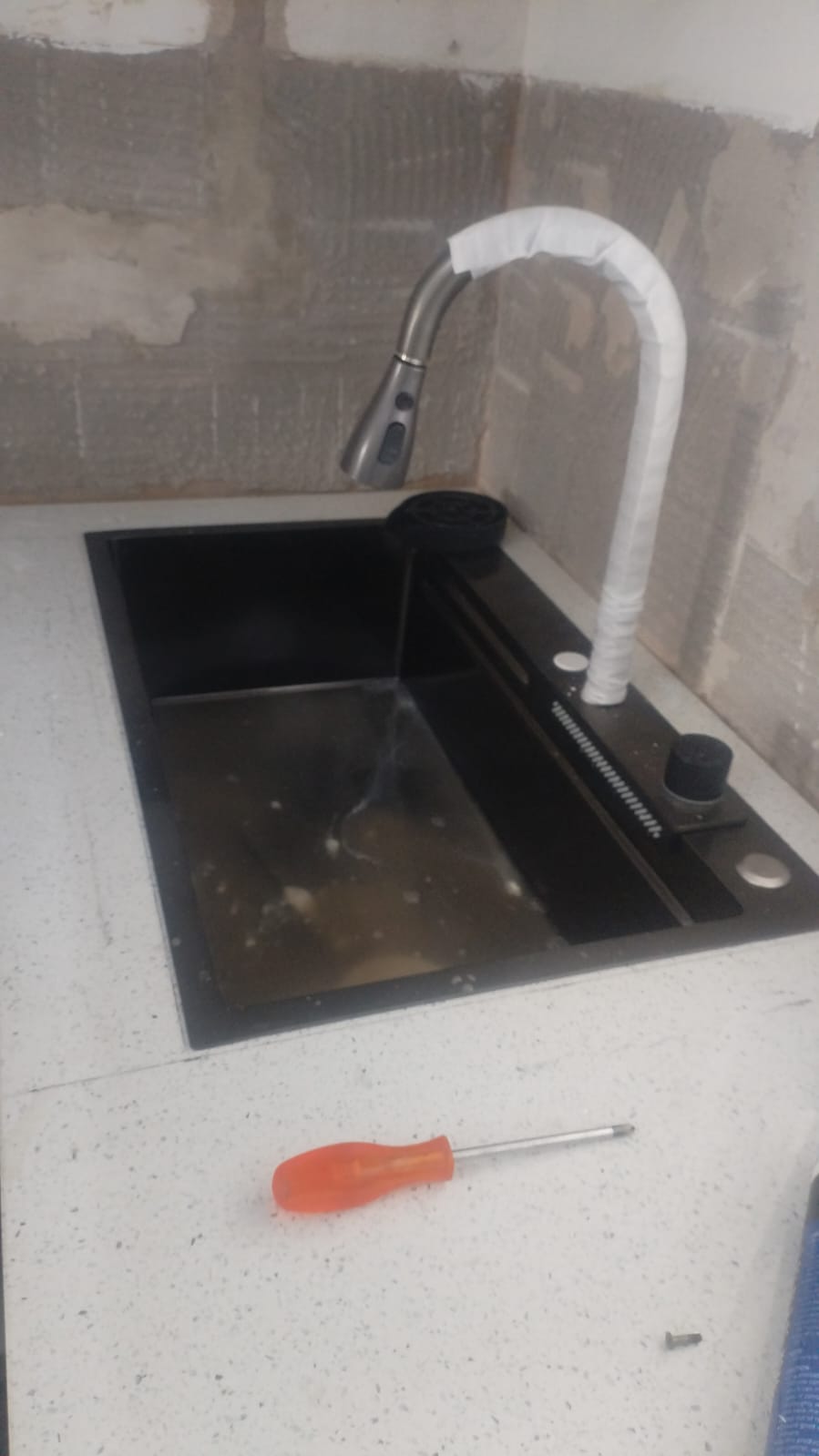 New kitchen mixer tap installed at a sink